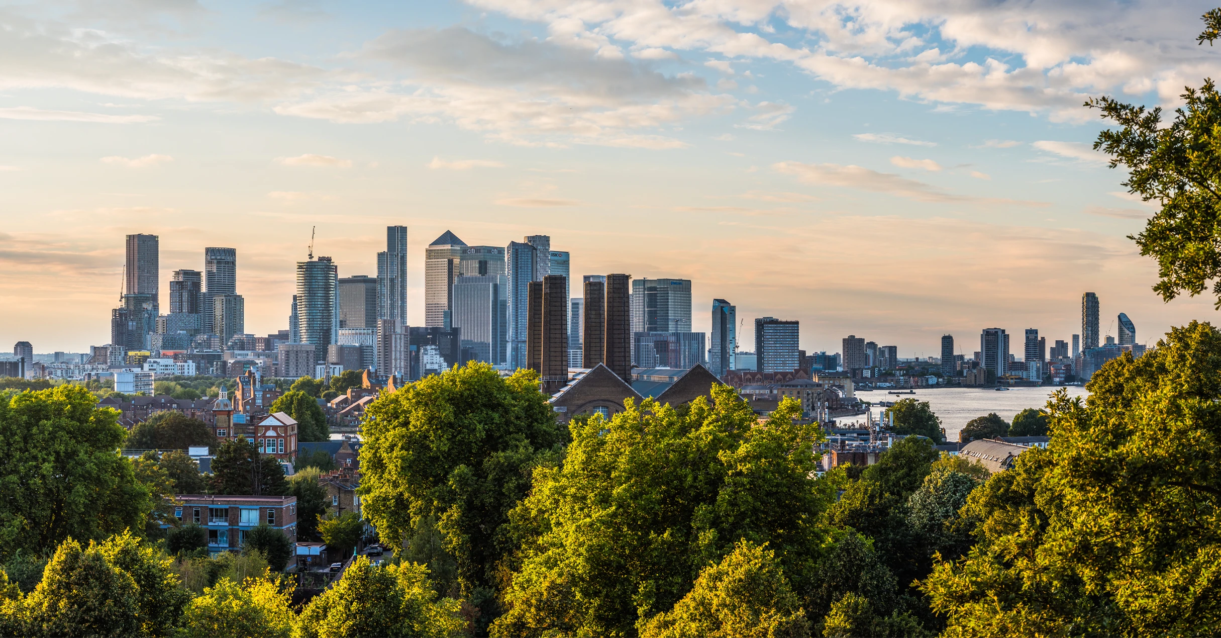 The image shows the skyline of London, with the Canary Wharf business district in the background