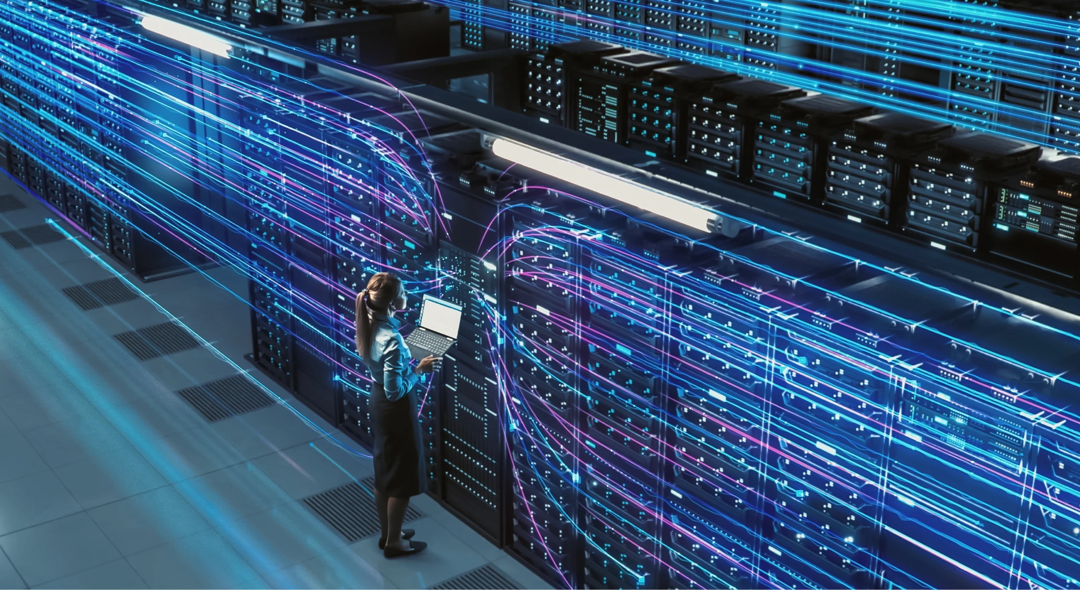Technician checking servers with a laptop in a data centre